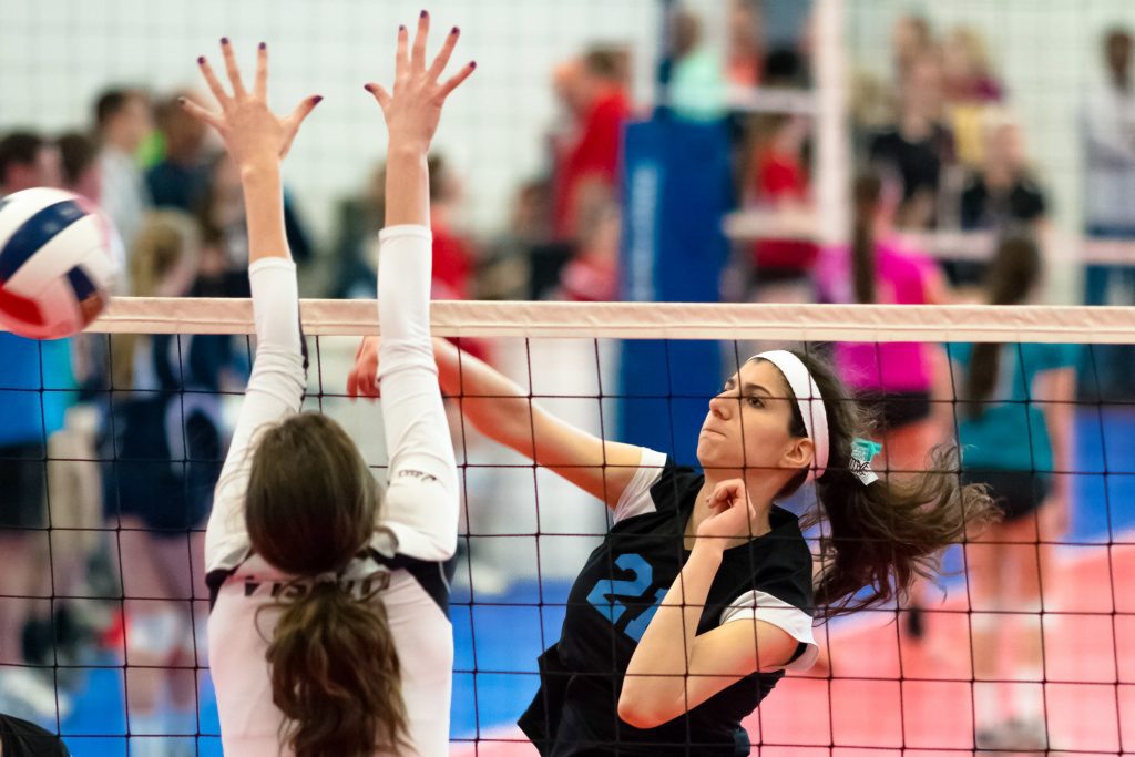 A woman hitting the ball with her arm.