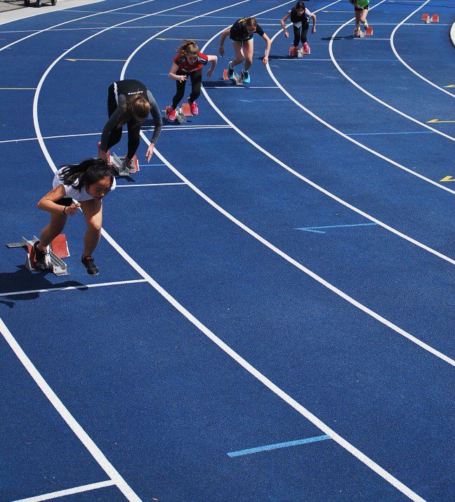 A group of people running on a track.